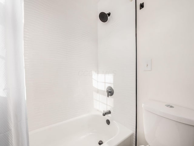 bathroom featuring toilet and shower / bath combo with shower curtain