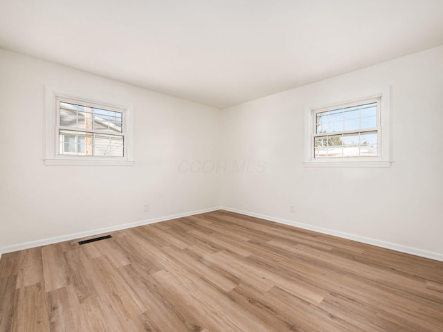 empty room with light hardwood / wood-style flooring