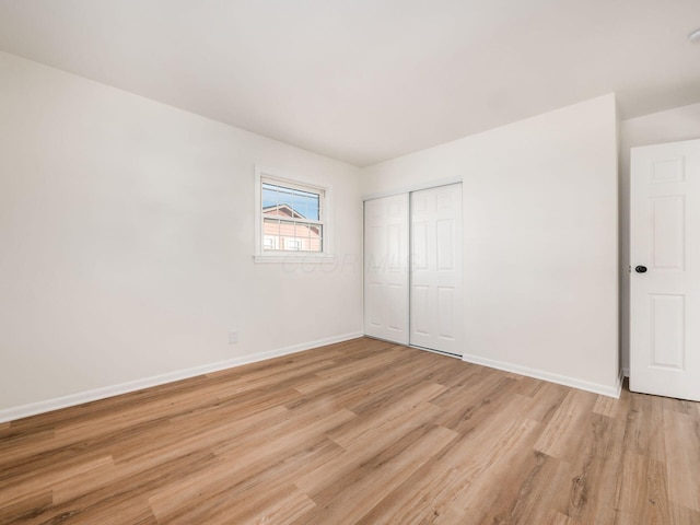 unfurnished bedroom featuring a closet and light wood-type flooring