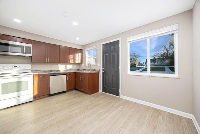 kitchen with light hardwood / wood-style floors, appliances with stainless steel finishes, and sink