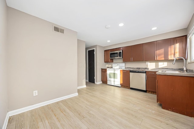 kitchen with sink, stainless steel appliances, and light wood-type flooring