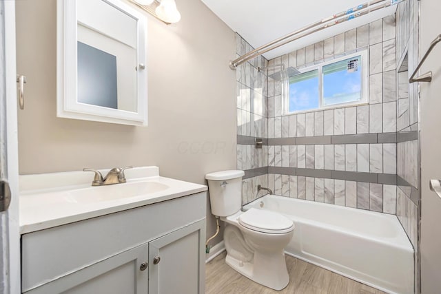 full bathroom featuring wood-type flooring, toilet, vanity, and tiled shower / bath