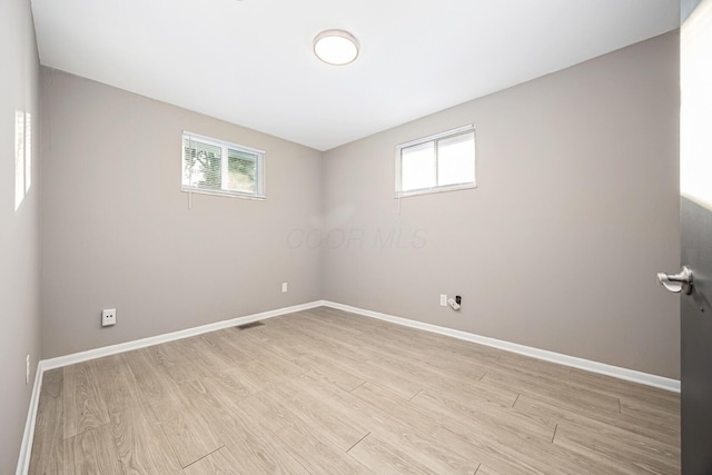 empty room featuring a healthy amount of sunlight and light hardwood / wood-style flooring