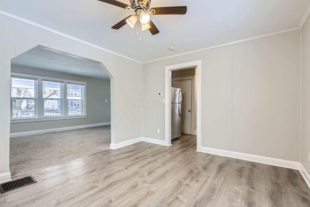 unfurnished room featuring crown molding, ceiling fan, and light hardwood / wood-style flooring