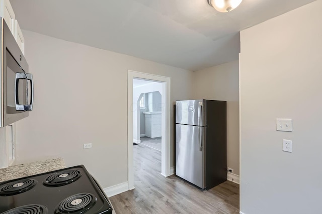 kitchen featuring stainless steel appliances and light hardwood / wood-style flooring