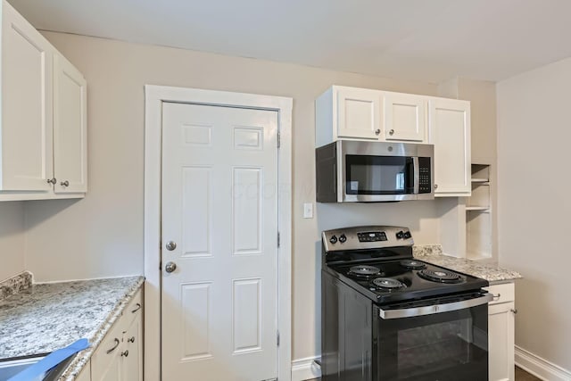 kitchen with electric stove, white cabinetry, and light stone counters