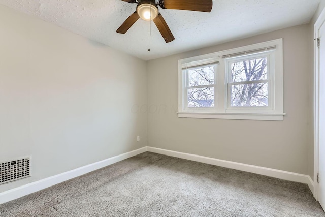 carpeted spare room with ceiling fan and a textured ceiling