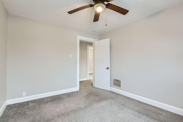 spare room with light colored carpet and a textured ceiling