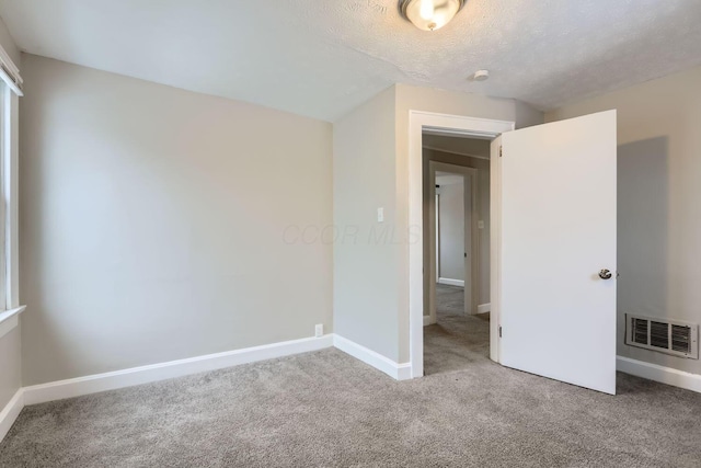 unfurnished bedroom with a textured ceiling and carpet flooring