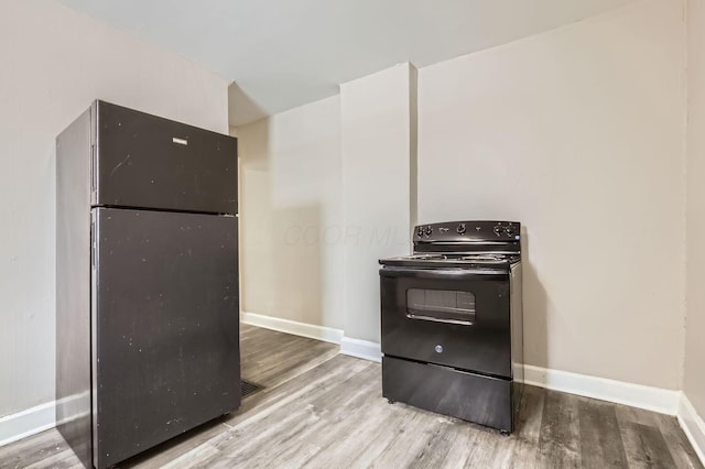 kitchen featuring light wood-type flooring and black appliances