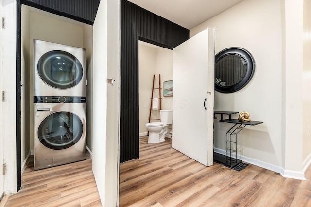 laundry room with hardwood / wood-style floors and stacked washer / drying machine