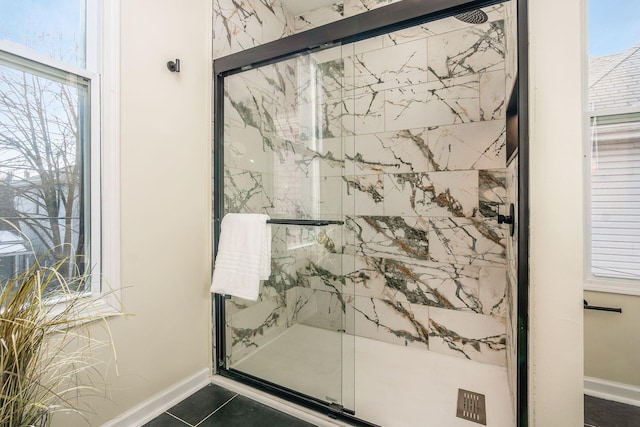 bathroom with a shower with door and tile patterned flooring