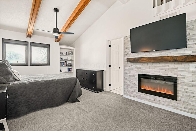 bedroom with ceiling fan, beam ceiling, high vaulted ceiling, a stone fireplace, and light colored carpet