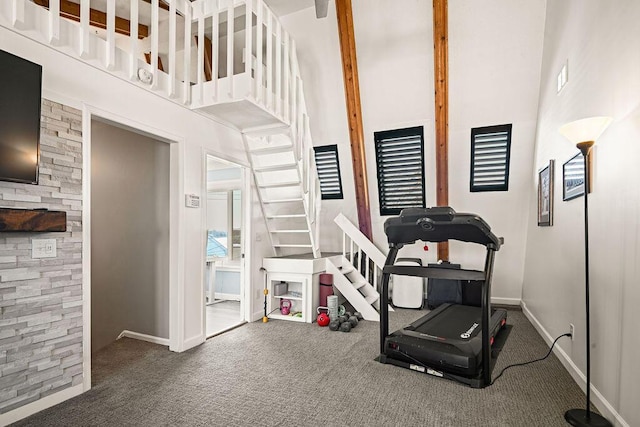 workout area featuring carpet flooring and a high ceiling