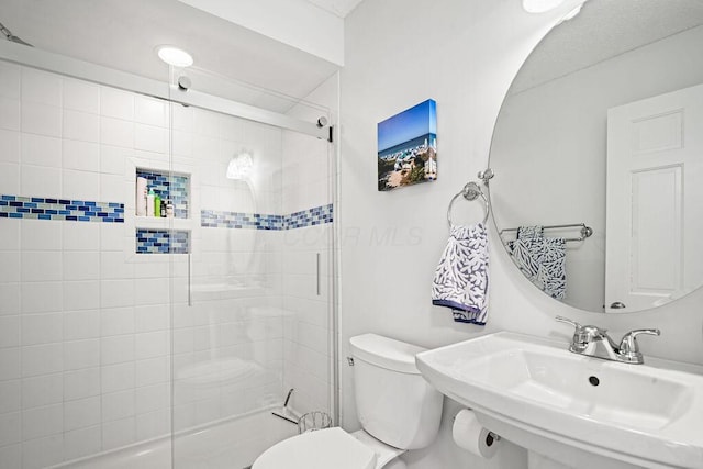 bathroom featuring toilet, an enclosed shower, and sink