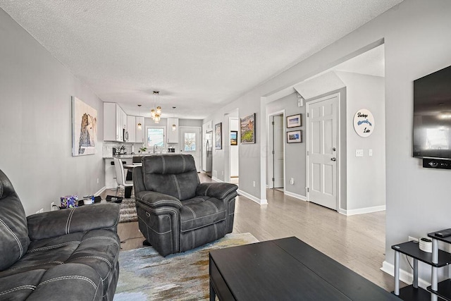 living room with light hardwood / wood-style flooring and a textured ceiling