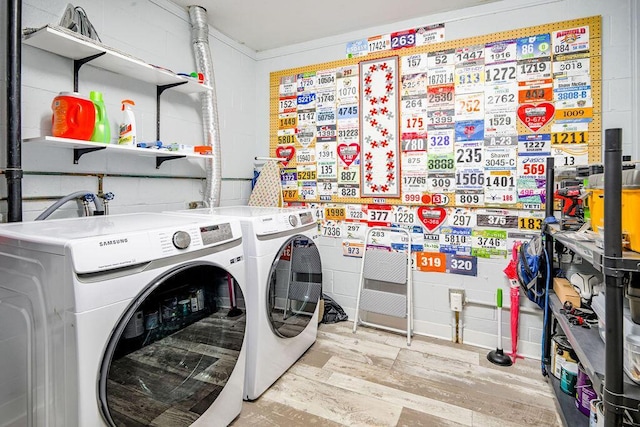 laundry area featuring light hardwood / wood-style flooring and washer and clothes dryer