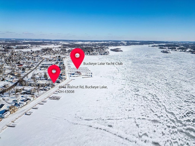 snowy aerial view with a water view