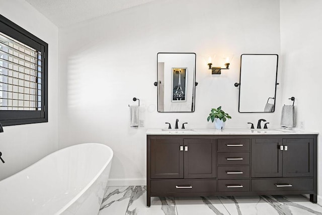 bathroom featuring vanity, a tub, and a textured ceiling