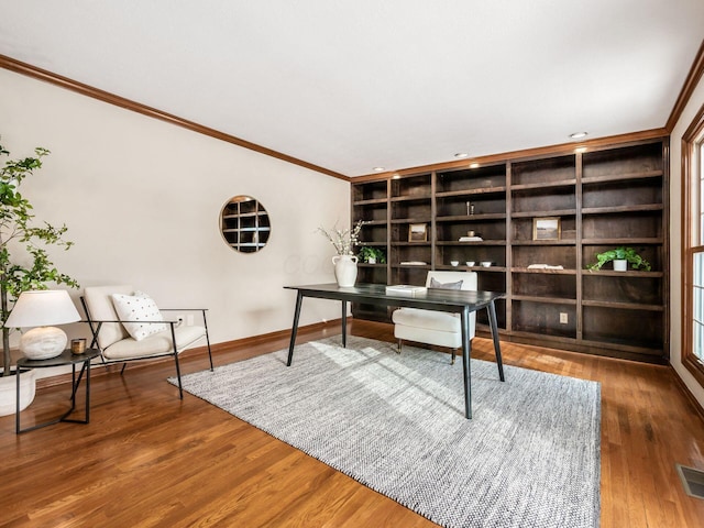 office featuring baseboards, built in shelves, wood finished floors, and crown molding