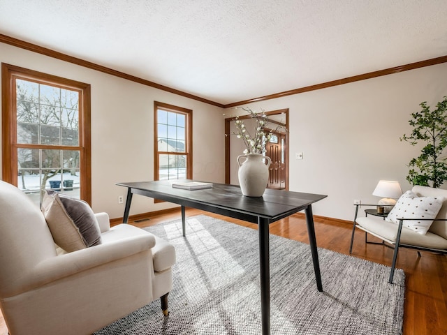 office with crown molding, a textured ceiling, baseboards, and wood finished floors