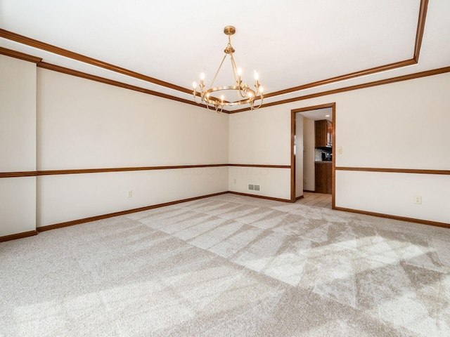 spare room featuring a notable chandelier, light colored carpet, visible vents, baseboards, and crown molding