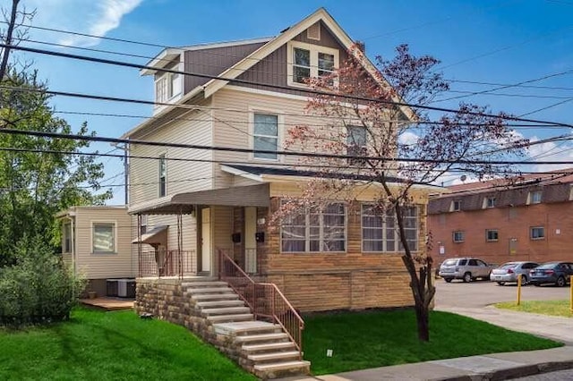 view of front of home with a front lawn and central AC