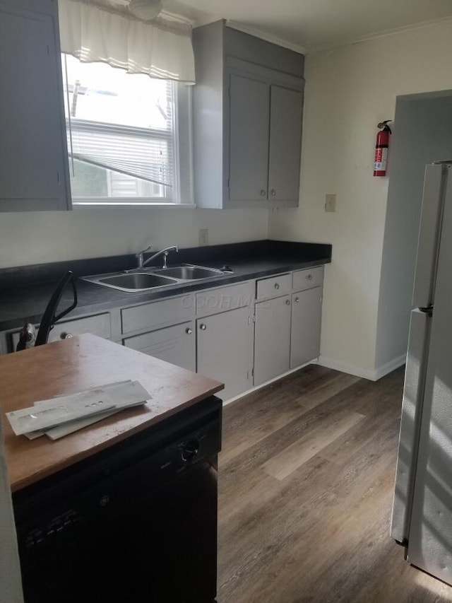 kitchen with light hardwood / wood-style floors, sink, dishwasher, and white refrigerator