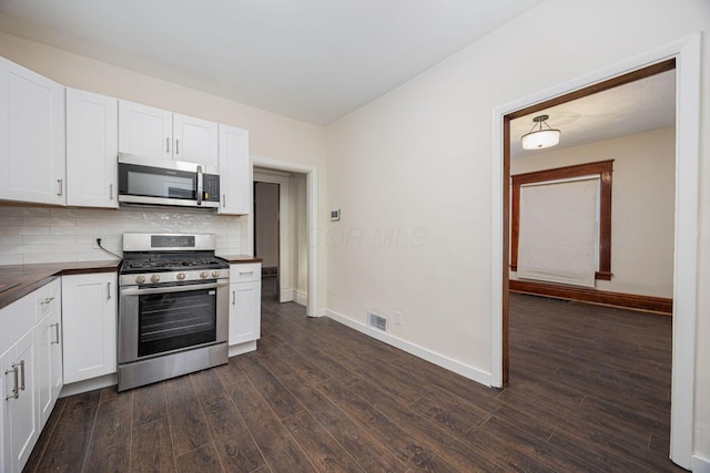 kitchen with backsplash, stainless steel appliances, dark hardwood / wood-style floors, and white cabinets