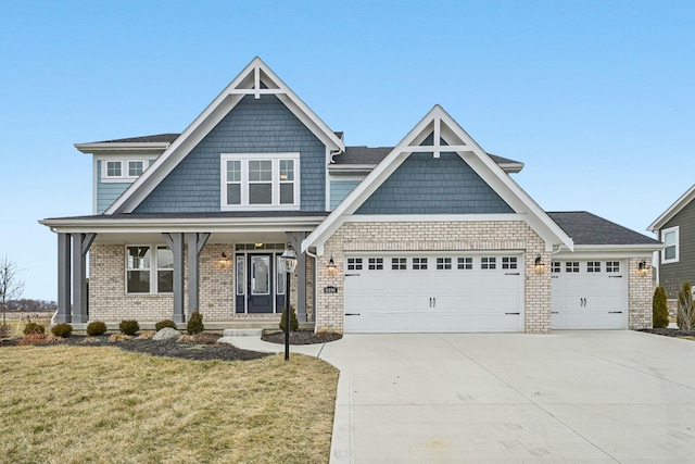 view of front of property featuring a porch, a garage, and a front lawn