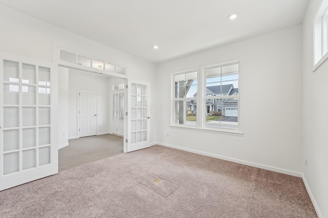 spare room featuring french doors and carpet