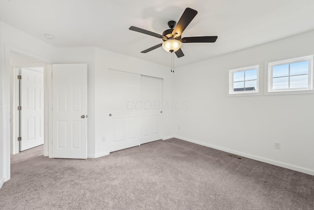 unfurnished bedroom featuring carpet, ceiling fan, and a closet