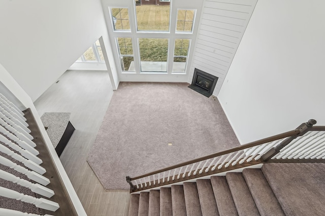 stairs featuring a towering ceiling and a fireplace