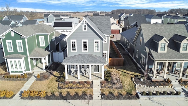 view of front of home with a residential view, a patio area, and roof with shingles