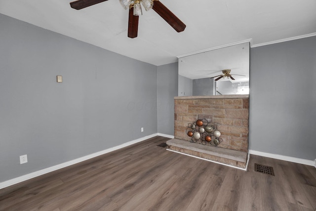 unfurnished living room with crown molding and dark wood-type flooring