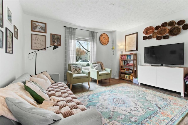 living room with dark wood-type flooring and a textured ceiling