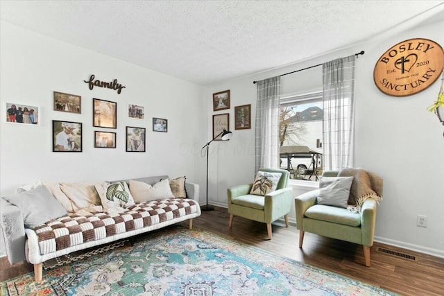 living area with wood-type flooring and a textured ceiling