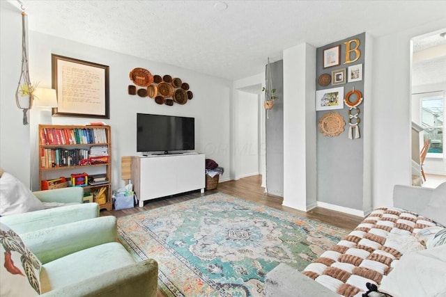 living room with a textured ceiling and dark hardwood / wood-style flooring