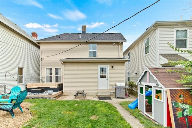 back of house with a yard, a storage shed, and an outdoor living space