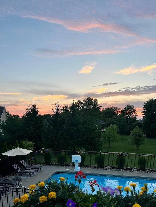 pool at dusk featuring a patio