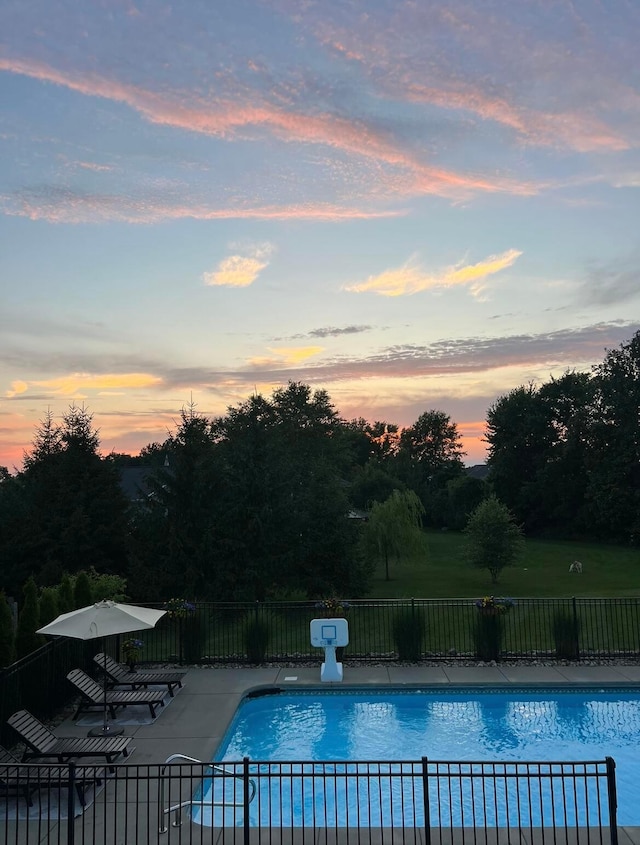 pool at dusk featuring a patio