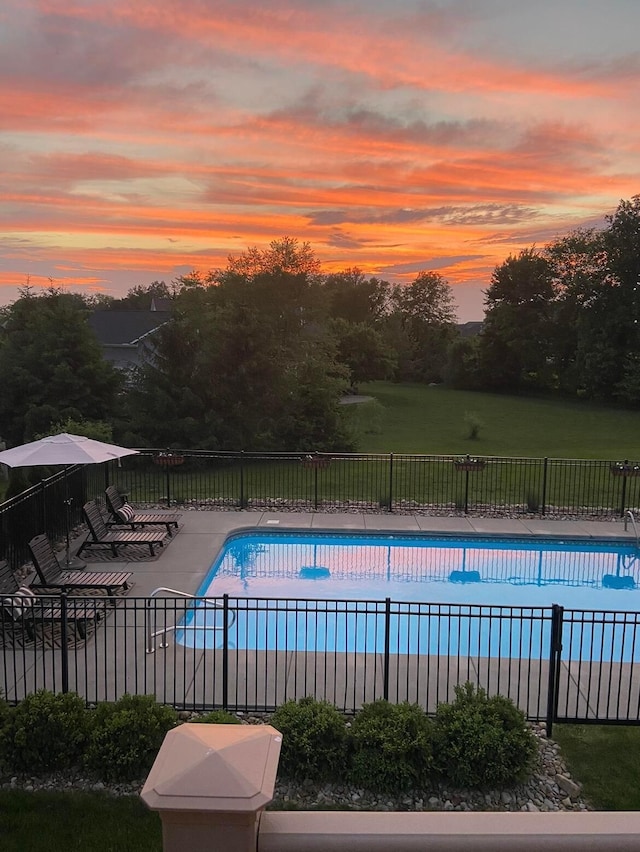 pool at dusk featuring a patio area