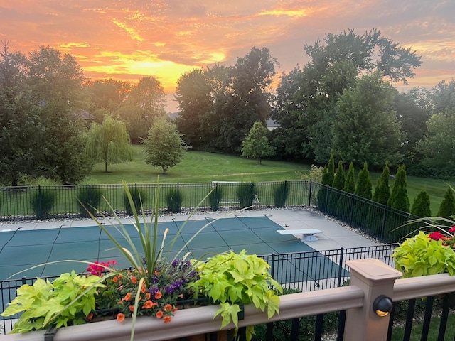 pool at dusk featuring a yard and a patio area