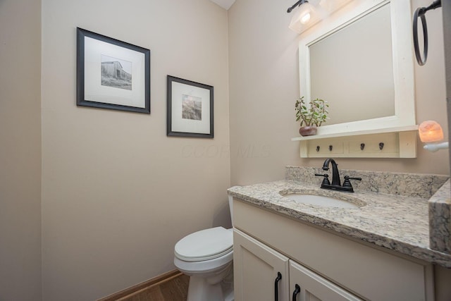 bathroom with vanity, hardwood / wood-style floors, and toilet