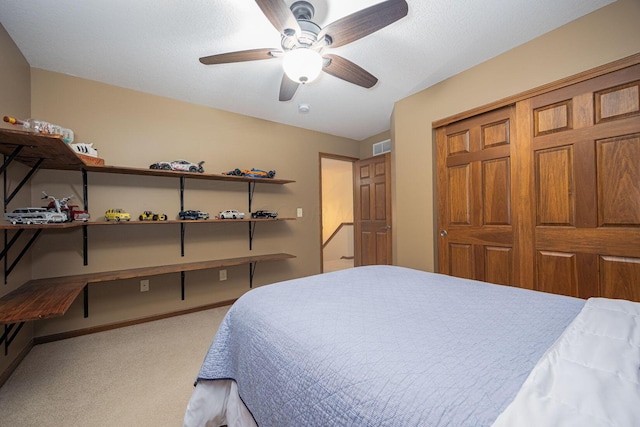 carpeted bedroom with ceiling fan and a closet