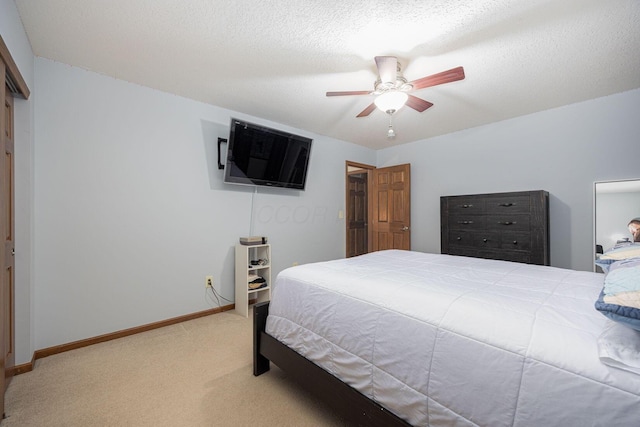 carpeted bedroom featuring a textured ceiling and ceiling fan