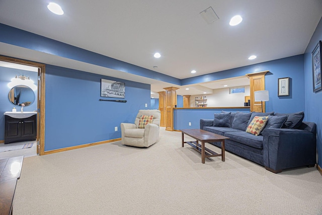 living room featuring decorative columns and light carpet