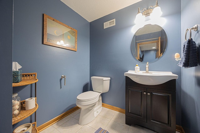 bathroom featuring tile patterned flooring, vanity, toilet, and a textured ceiling