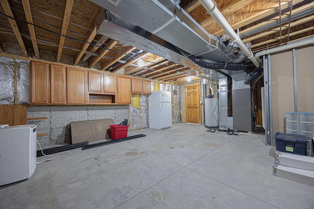 basement featuring heating unit, white fridge, and gas water heater