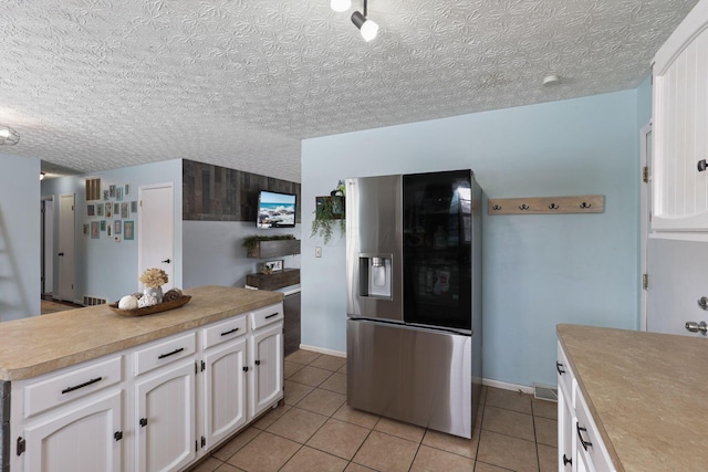 kitchen featuring white cabinetry, light tile patterned flooring, and stainless steel fridge with ice dispenser